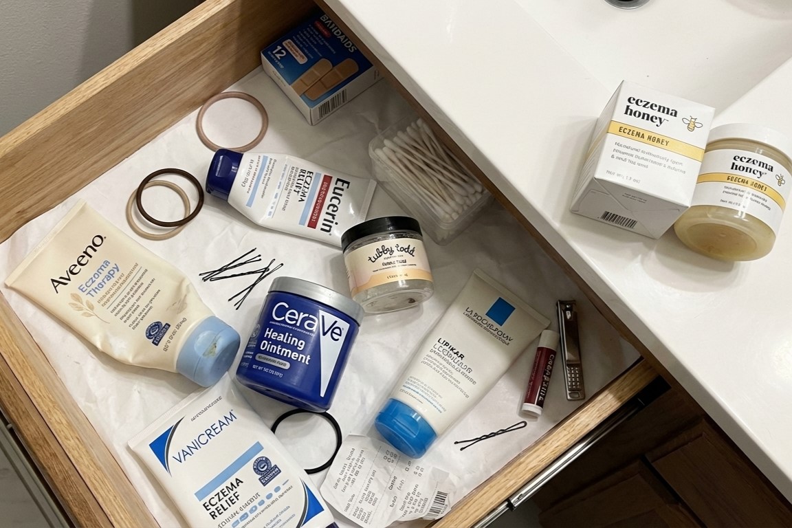 Woman looking concerned, touching her face in a bathroom.